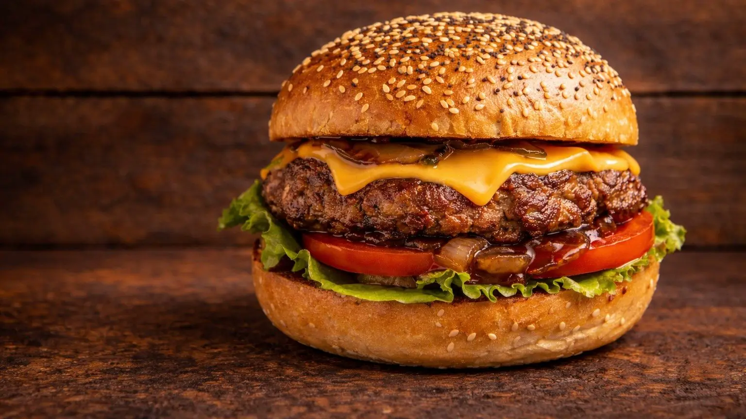 A grilled Texas Backyard burger on a toasted sesame bun.