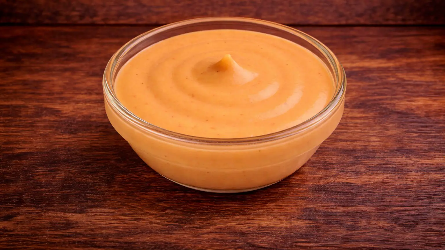 House sauce in a small glass bowl on a dark wood table at Texas Backyard.