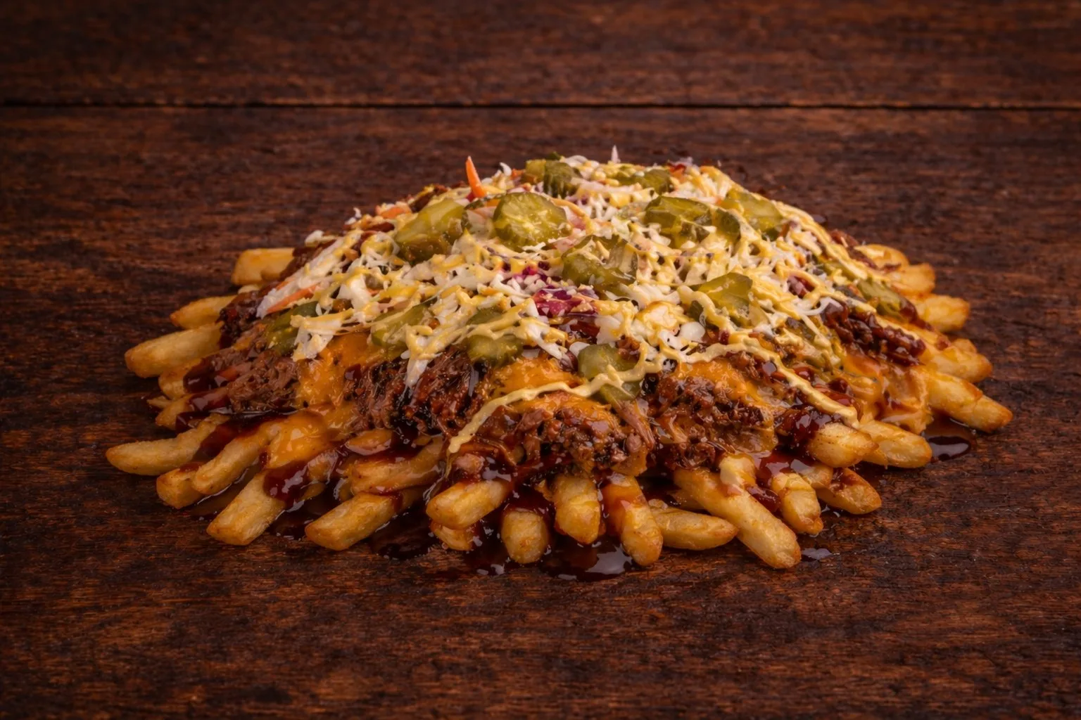 Pork fries at Texas Backyard: fries, pulled pork, cheddar, BBQ sauce, coleslaw, pickles, and mustard.
